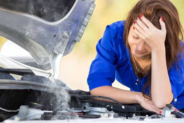 A woman with a broken car engine