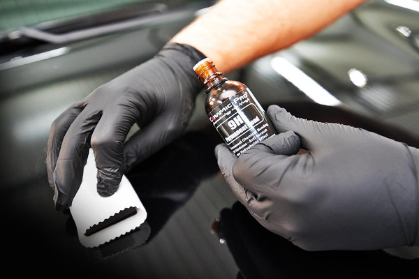 man applying color coating in the car's finish