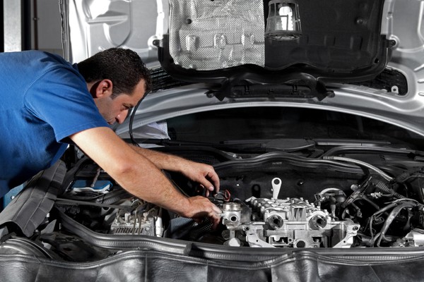 man repairing a car's engine