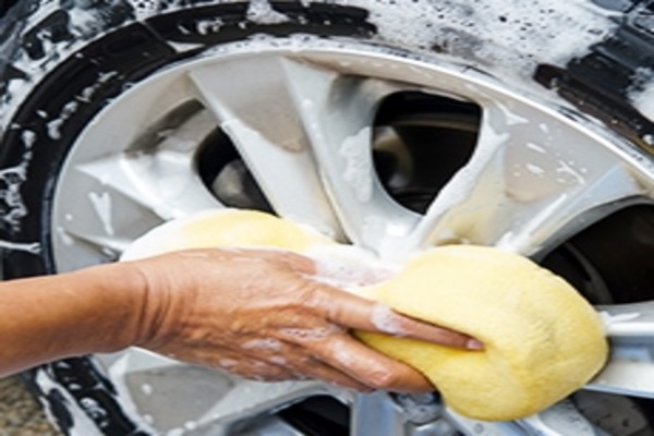 Man cleaning the car's wheel