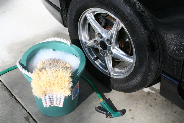 cleaning solution beside a car's wheel