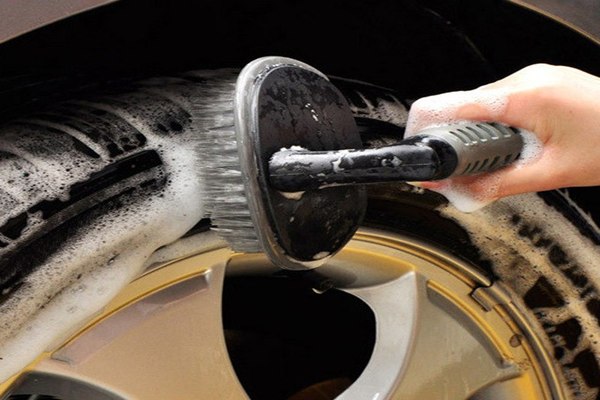 Man brushing the car's tire