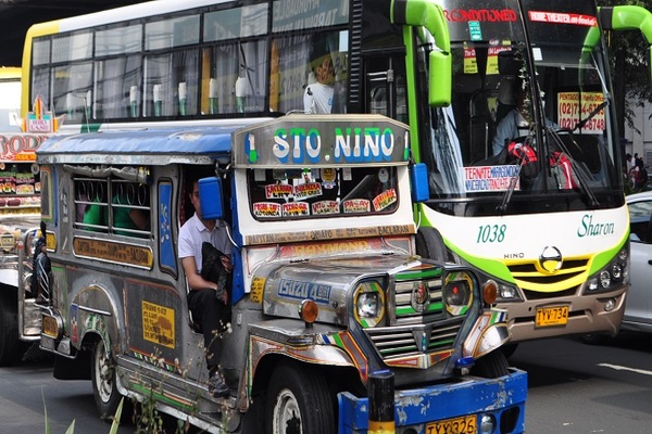 A jeepney and bus in the road