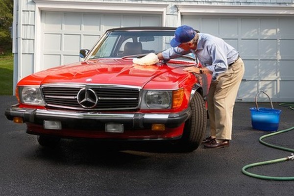Old man cleaning the car