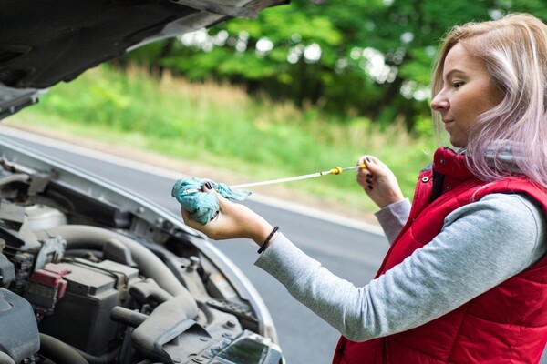 Girl checking the engine oil